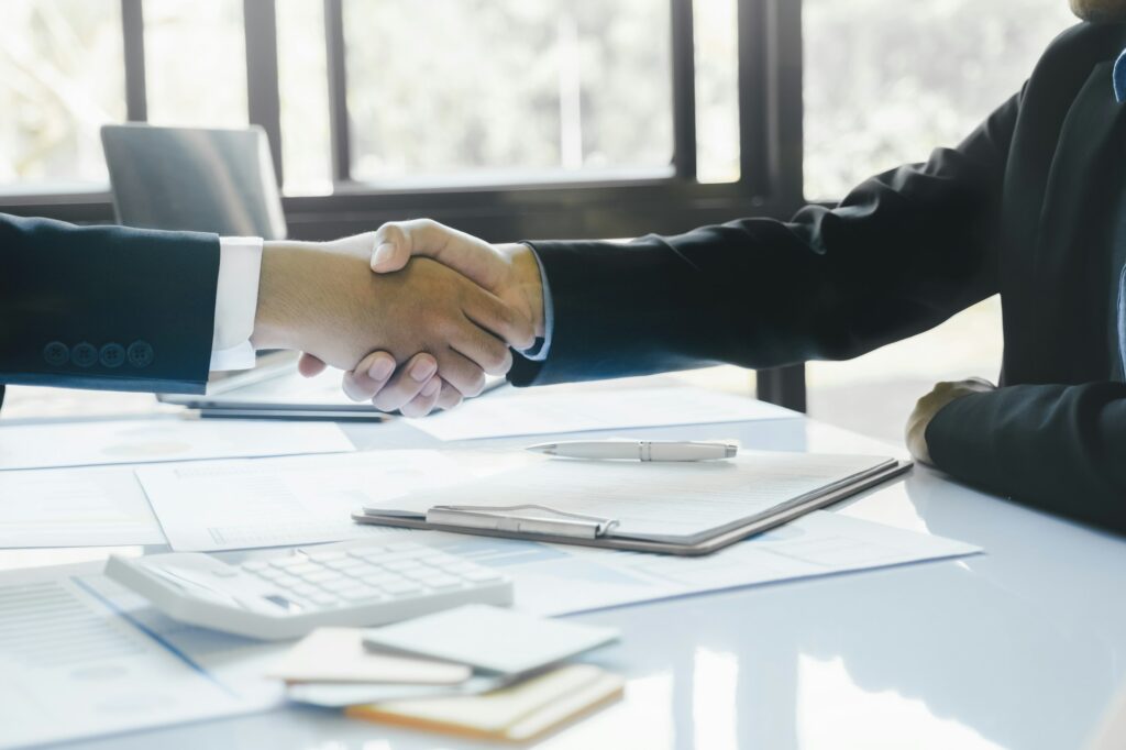 Close up businessman shaking hands with the client after finish the meeting.